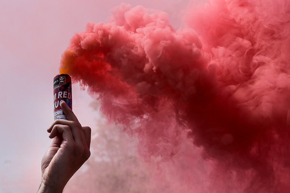 a man holds a flare during a may day rally in pristina photo afp