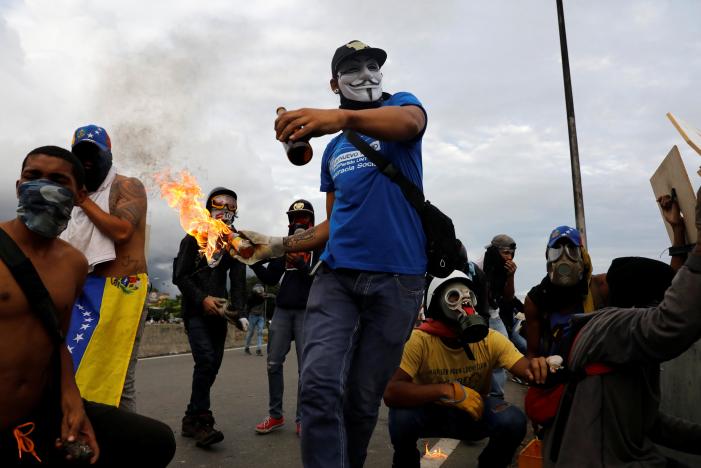 a demonstrator throws a molotov cocktail during clashes with riot police while rallying against venezuela 039 s president nicolas maduro in caracas venezuela may 1 2017 photo reuters