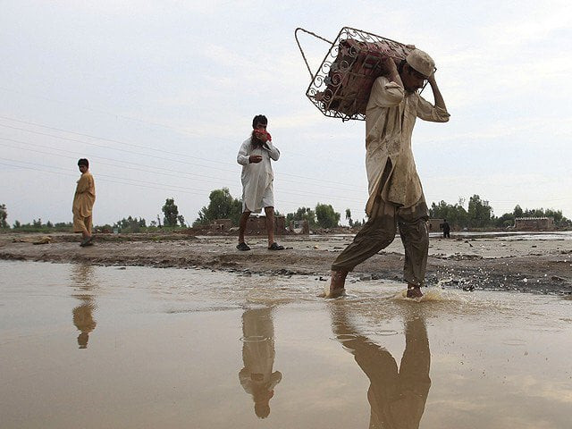 people walk through a flooded road in k p photo reuters people walk through a flooded road in k p photo reuters