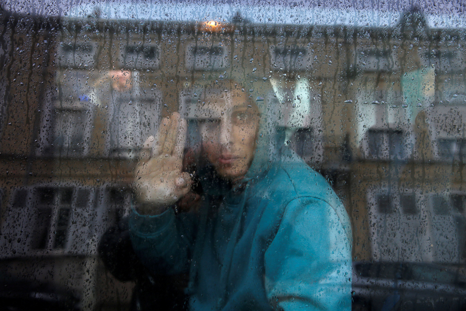 An adolescent Afghani migrant waves from a van as he departs with six others from the emergency shelter for minors in Saint Omer, France as they leave for Britain. PHOTO: REUTERS
