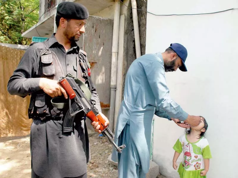 a paramilitary soldier stands guard as an inoculator administers polio vaccine drops to a child during a recent anti polio drive in rawalpindi photo online a paramilitary soldier stands guard as an inoculator administers polio vaccine drops to a child during a recent anti polio drive in rawalpindi photo online