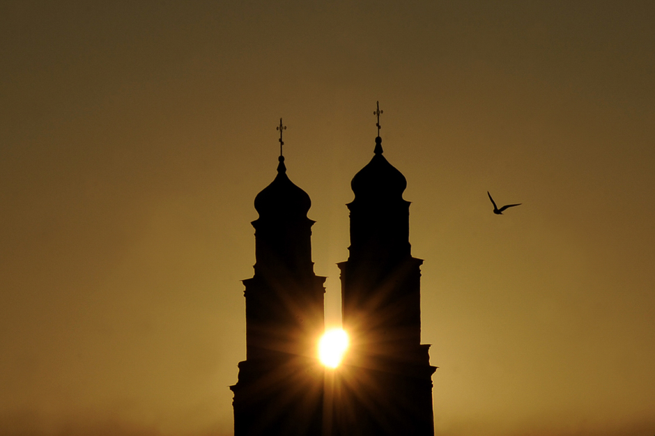 a seagull flies close to the orthodox nativity cathedral during sunrise in the town of glubokoye some 170 km northwest of minsk photo afp