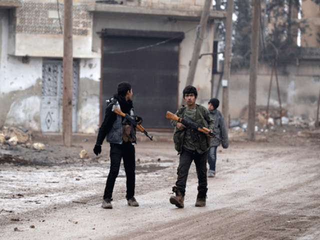 youth carry weapons along a road in al rai town northern aleppo countryside syria photo reuters