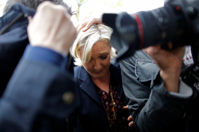 marine le pen french national front fn party candidate for 2017 presidential election is protected by bodyguards as eggs are thrown by demonstrators during her arrival in dol de bretagne france may 4 2017 photo reuters