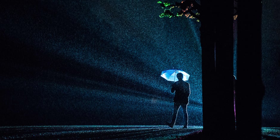 a visitor silhouettes against rays of light of the installation quot painting the night quot by austrian artist victoria coeln as rain falls on the herrenhaeuser gaerten park in hanover northern germany photo afp