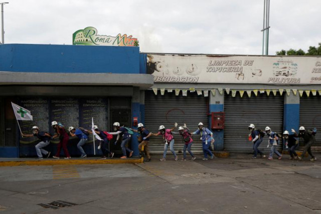 volunteers members of a primary care response team walk together as demonstrators clash with police during a rally against venezuela 039 s president nicolas maduro in caracas venezuela photo reuters volunteers members of a primary care response team walk together as demonstrators clash with police during a rally against venezuela 039 s president nicolas maduro in caracas venezuela photo reuters