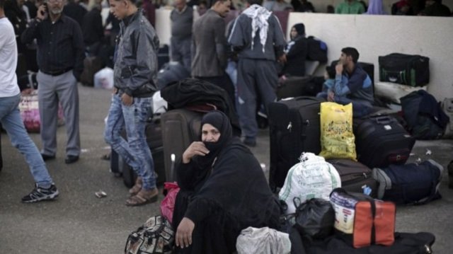 a palestinian woman sits next to her luggage as she waits to cross to the egyptian side of the rafah border crossing in rafah gaza strip photo ap