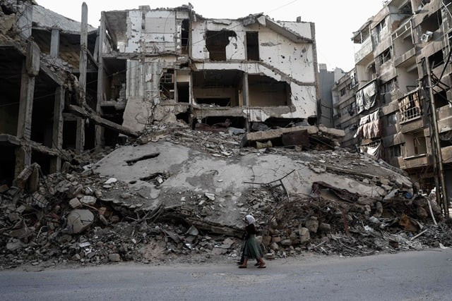 syrian girls walk past destroyed buildings in the rebel held town of douma on the eastern outskirts of damascus on may 6 2017 photo afp syrian girls walk past destroyed buildings in the rebel held town of douma on the eastern outskirts of damascus on may 6 2017 photo afp