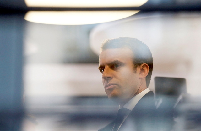 emmanuel macron head of the political movement en marche or onwards and candidate for the 2017 presidential election is pictured through a window of his hotel during a campaign visit in rodez france may 5 2017 photo afp