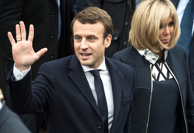 french presidential election candidate emmanuel macron waves to supporters next to his wife brigitte trogneux after voting for the second round of the french presidential election photo afp