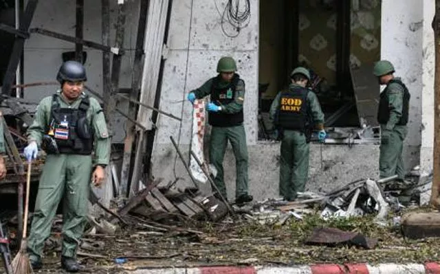 a thai bomb squad inspects the site of a bomb blast photo afp a thai bomb squad inspects the site of a bomb blast photo afp