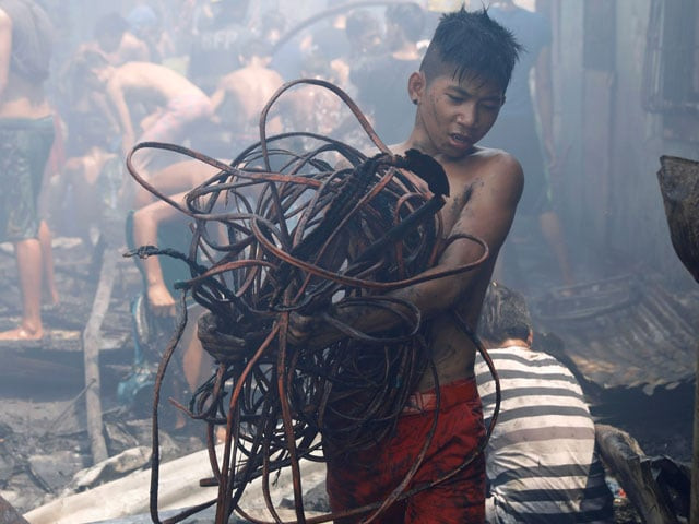 a resident carries a bunch of electric wires after a fire razed a squatter colony in manila philippines may 9 2017 photo reuters a resident carries a bunch of electric wires after a fire razed a squatter colony in manila philippines may 9 2017 photo reuters
