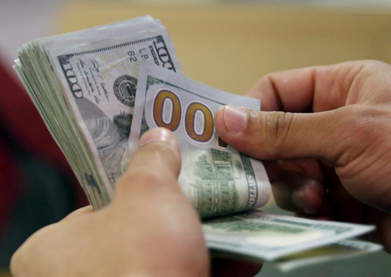 a customer counts his us dollar money in a bank photo reuters