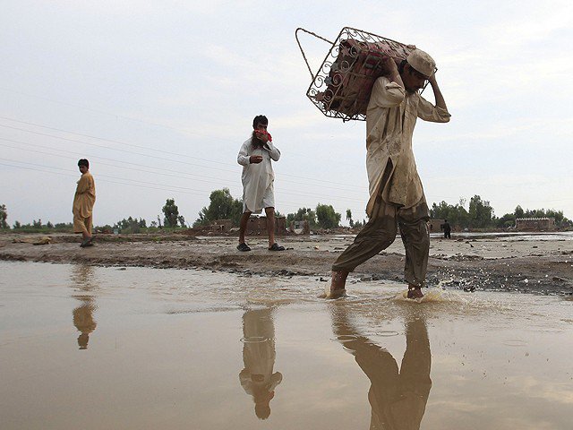 people walk through a flooded road in k p photo reuters