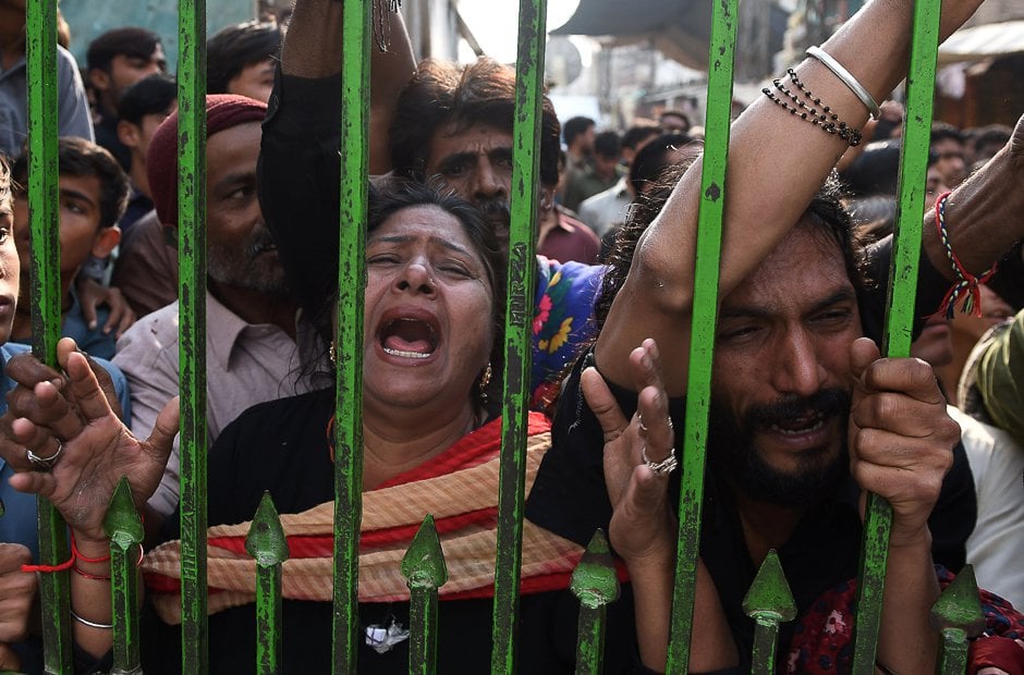 devotees gather outside closed gate of lal shahbaz qalandar shrine after a suicide attack killed over 90 people photo afp