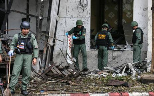 a thai bomb squad inspects the site of a bomb blast photo afp