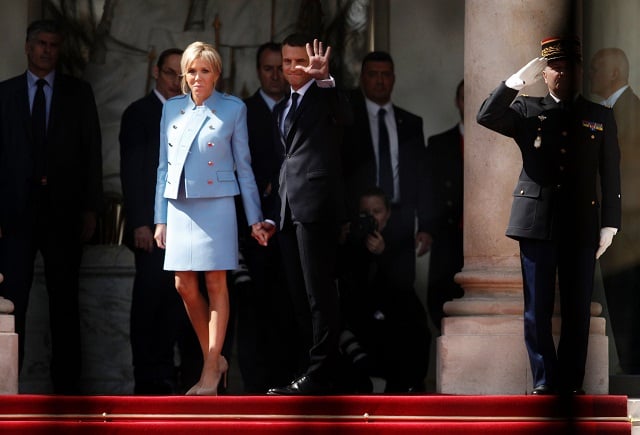 french newly elected president emmanuel macron r waves as he poses with his wife brigitte trogneux at the elysee presidential palace after the handover and prior to the inauguration ceremony on may 14 2017 in paris photo afp