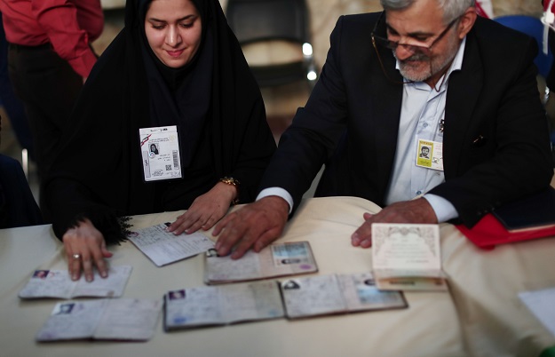 election officials check people 039 s id cards at a polling station in tehran on may 19 2017 photo afp