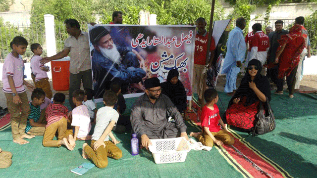 fundraising wearing a black jinnah cap faisal sits with a basket in front of him surrounded by orphaned children of the clifton edhi centre to collect donations photo express