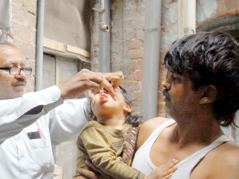 a vaccinator administers oal polio vaccine to a child photo ppi