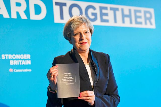 britain 039 s prime minister theresa may holds up the conservative party general election manifesto as she speaks at the launch event in halifax in northern england photo afp