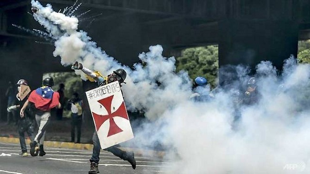 opposition activists clash with riot police in caracas as doctors rally in venezuela in the latest street protests against the government of president nicolas maduro photo afp