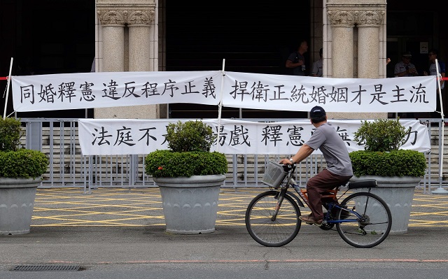 a man rides pass a banner read quot constitutional interpretation on same sex marriage violates procedural justice quot in front of judicial yuan in taipei on may 24 2017 taiwan could become the first place in asia to legalise gay marriage when a court makes a landmark ruling on whether to allow same sex unions photo afp