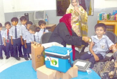 a health worker administers a polio booster dose to a student through a needle free jet injector during the launch of an anti polio vaccination campaign at a school the initiative aims to strengthen immunisation coverage among children using modern less invasive vaccination technology photo jalal qureshi express