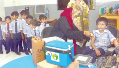 a health worker administers a polio booster dose to a student through a needle free jet injector during the launch of an anti polio vaccination campaign at a school the initiative aims to strengthen immunisation coverage among children using modern less invasive vaccination technology photo jalal qureshi express
