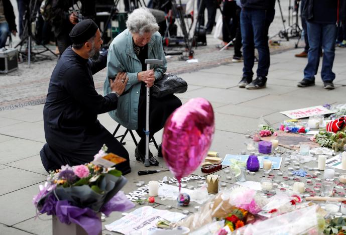 a muslim man named sadiq patel comforts a jewish woman named renee rachel black next to floral tributes in albert square in manchester britain may 24 2017 photo reuters