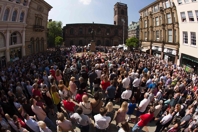 in this picture made using a fish eye lens people gather to observe a minute 039 s silence around the tributes in st ann 039 s square in central manchester northwest england on may 25 2017 photo afp