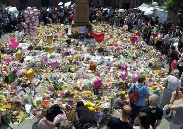 crowds look at the balloons flowers and messages of condolence left for the victims of the manchester arena attack in central manchester britain may 25 2017 photo reuters