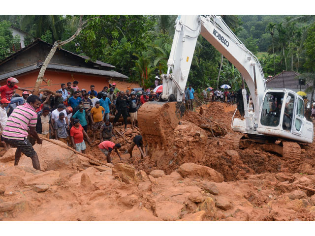 sri lankan military rescue workers and villagers search for survivors at the site of a mudslide in bellana village in kalutara on may 26 2017 photo afp