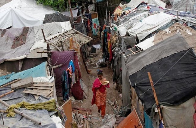 a girl carries flat bread for lunch as she walks past makeshift tents in a slum in karachi pakistan photo reuters a girl carries flat bread for lunch as she walks past makeshift tents in a slum in karachi pakistan photo reuters