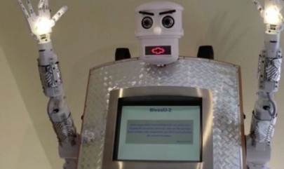robot priest beams light from its hands and gives automated blessings