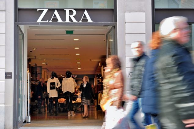 pepole walk in front of the entrance of a zara clothing store photo afp