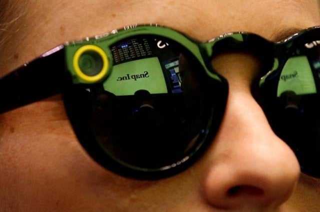 a woman wears snapchat spectacles on the floor of the new york stock exchange nyse while waiting for snap inc to list their ipo in new york u s march 2 2017 photo reuters