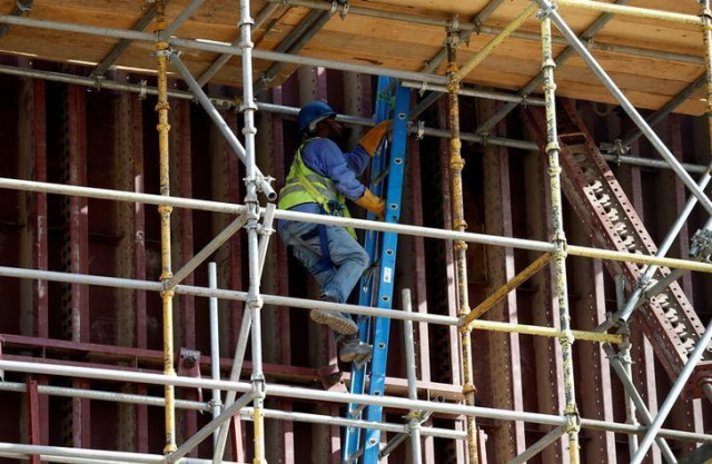 a labourer climbs a ladder at a construction site photo reuters a labourer climbs a ladder at a construction site photo reuters