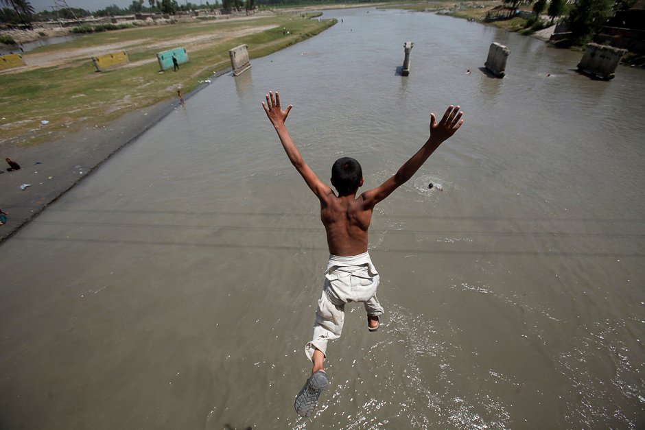 a man jumps into a canal to cool off during a heatwave in lahore pakistan photo reuters