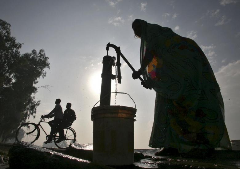 a women uses a hand pump to fill drinking water photo reuters