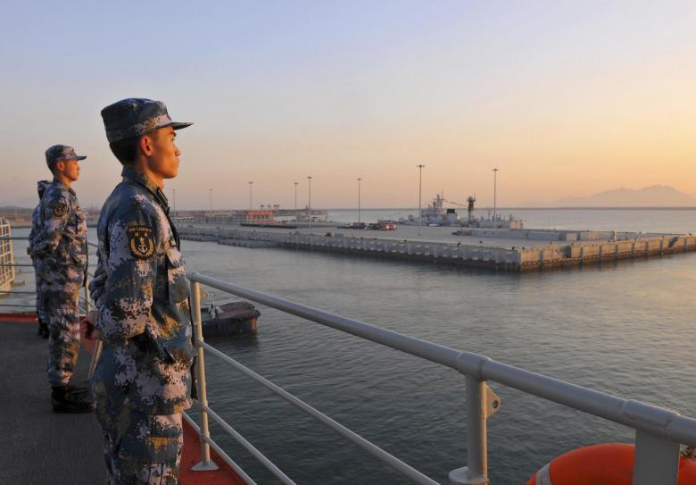 chinese naval soldiers stand guard on china 039 s first aircraft carrier liaoning as it travels towards a military base in sanya hainan province photo reuters