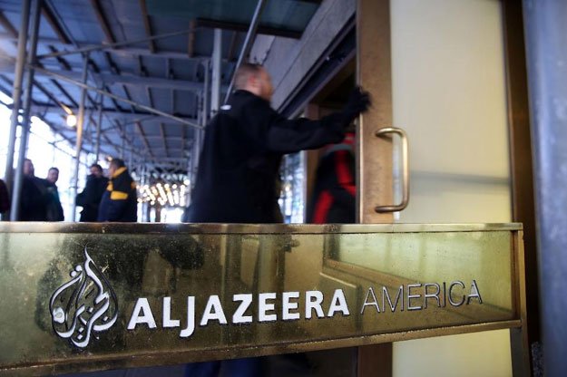 people walk into the offices of al  jazeera america on january 13 2016 in new york city photo afp