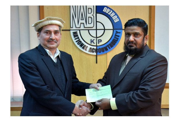 nab director general shahzad saleem handing over the cheque to additional finance secretary razaullah photo express