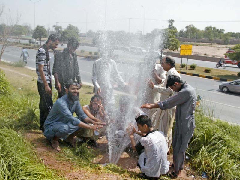 people enjoy a roadside shower on a hot day thanks to a leaked pipeline of cda photo online