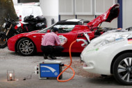 a man prepares his tesla roadster electric car at he world 039 s biggest electric vehicle rally the wave trophy in zurich switzerland photo reuters