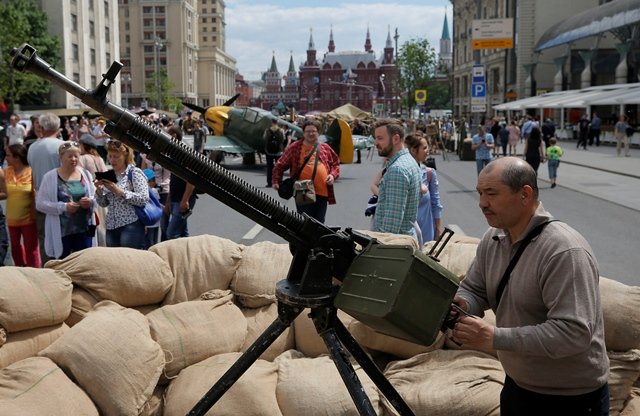 a man looks over an anti aircraft machine gun during a re enactment festival which coincides with an anti corruption protest organised by opposition leader alexei navalny on tverskaya street in central moscow russia june 12 2017 photo reuters