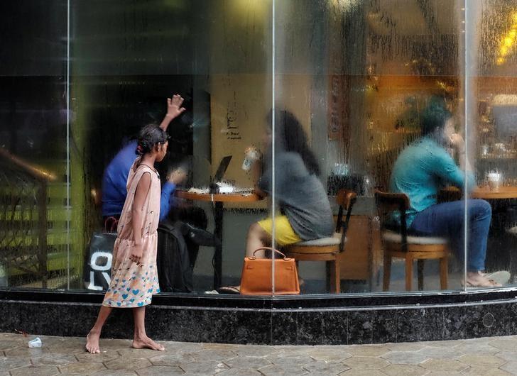 a homeless girl asks for alms outside a coffee shop photo reuters