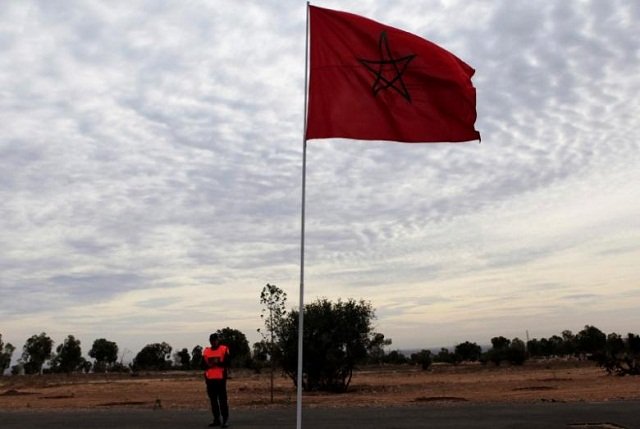 file photo of a police officer standing near a moroccan national flag photo reuters