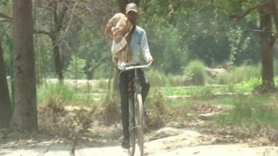 indian man cycles home carrying dead niece on shoulder indian man cycles home carrying dead niece on shoulder