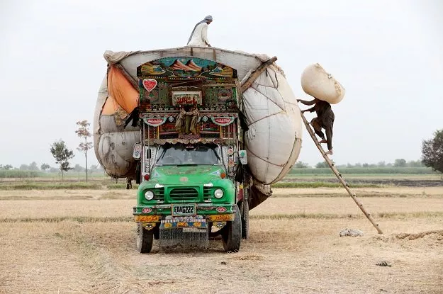 workers load straw onto a decorated truck outside faisalabad pakistan photo reuters workers load straw onto a decorated truck outside faisalabad pakistan photo reuters